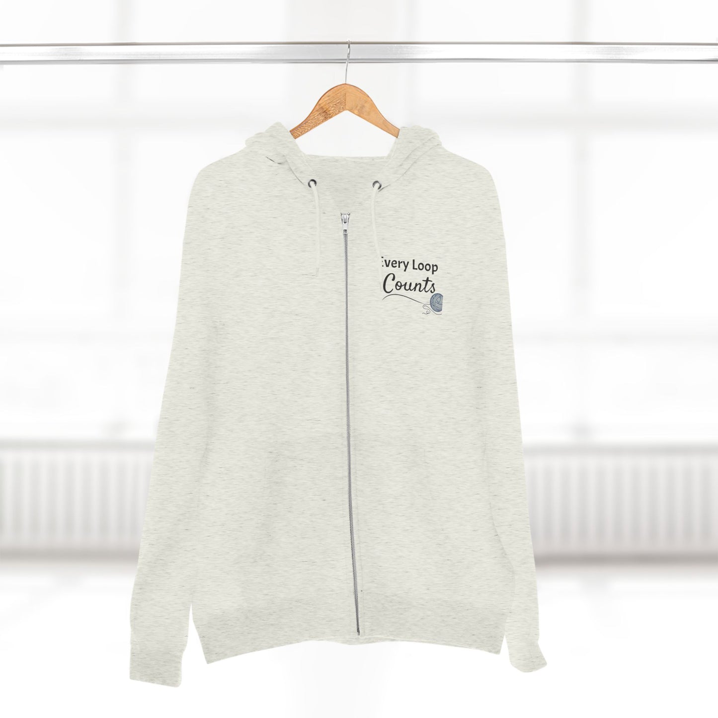Light gray zip-up hoodie with text on a wooden hanger against a white background