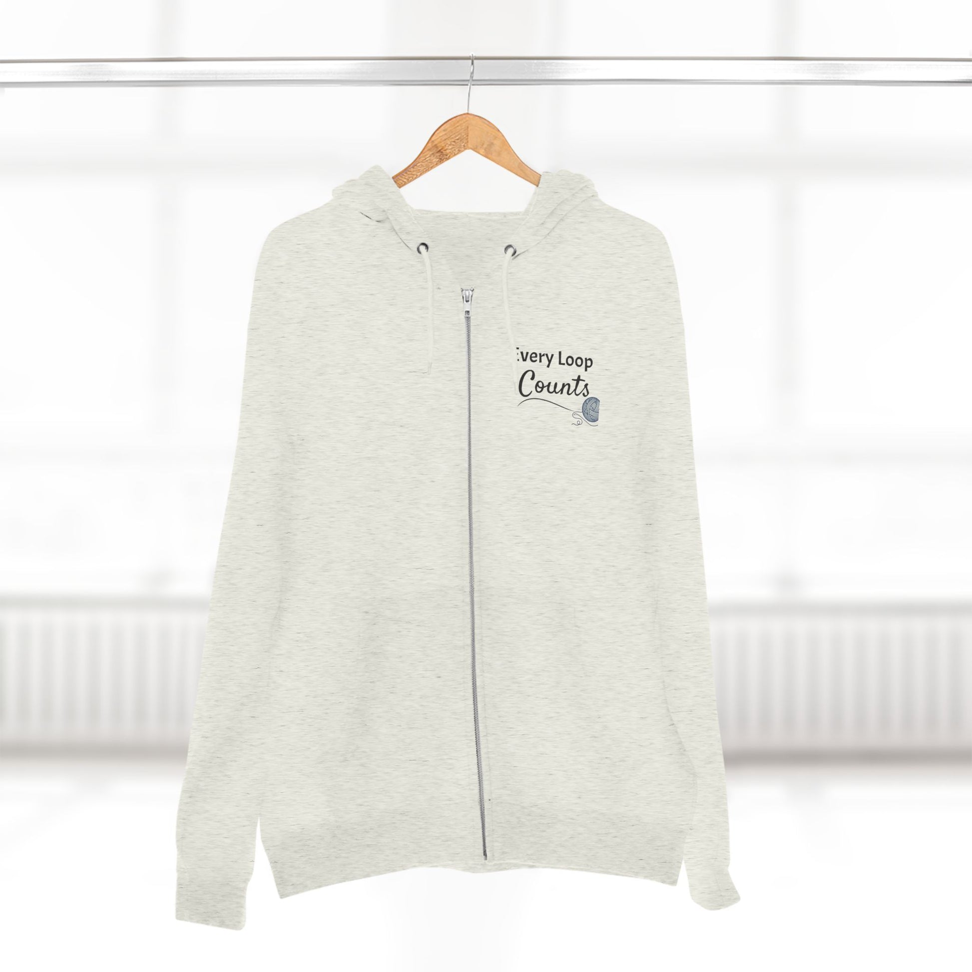 Light gray zip-up hoodie with text on a wooden hanger against a white background
