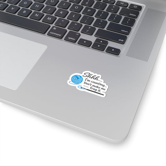 Die-cut kiss-cut sticker with a blue yarn ball and crochet hook graphic and the text 'Shhh... I'm counting... Don't make me frog it.'"